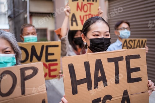 Preview: Asian protesters in face masks with placards on city street