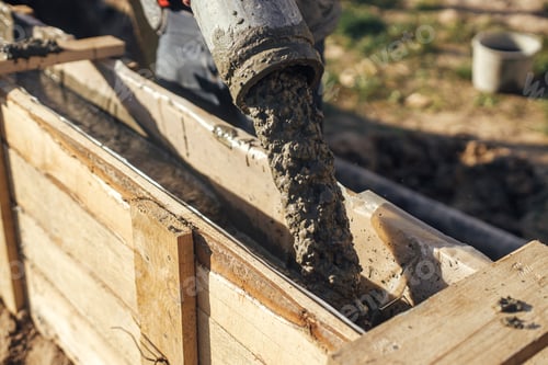 Preview: Builders pouring concrete with pump truck in wooden formwork with reinforcement. Construction site