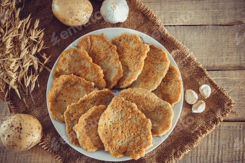 Preview: Potato pancakes on plate. Traditional belorussian or ukrainian dish on linen background.Fried latkes