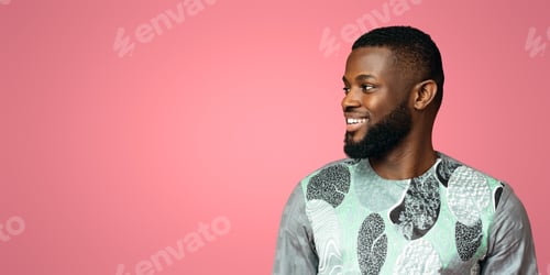 Preview: Positive black man in african shirt looking at copy space