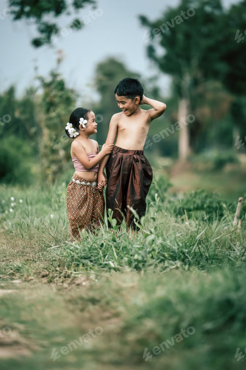 Preview: Lovely kids in Thai traditional dress stand and looking on sky