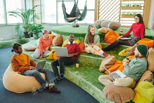 Preview: Happy young intercultural managers discussing new ideas at start-up meeting