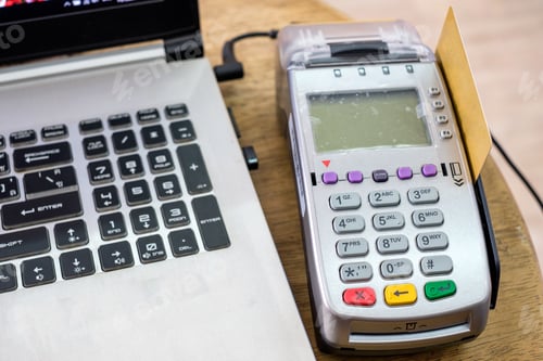 Preview: Using swipe credit card on payment terminal with laptop on table