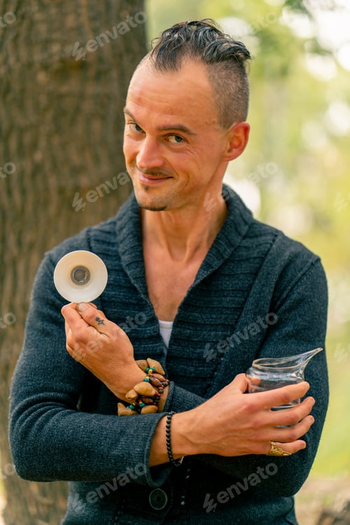 Preview: Smiling tea master looking at camera and showing beautiful tea bowl