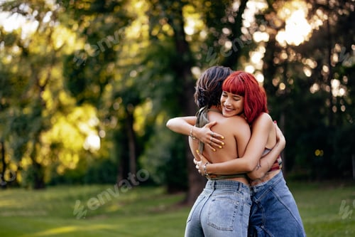 Vista previa: Two Women Embracing Affectionately Outdoors in a Natural Park Setting