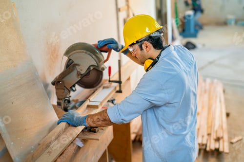 Preview: Top view of Caucasian carpenter man use electrical saw to work with timber in factory workplace.