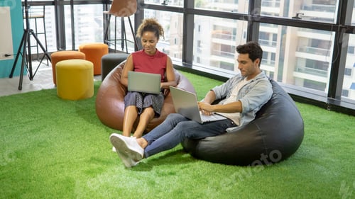 Preview: Mix race women discussing with colleagues on laptop computer in the new startup office.