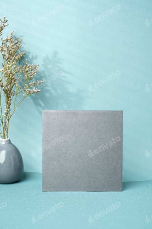 Preview: blank poster paper with flower in ceramic vase and window sunlight on pastel blue background