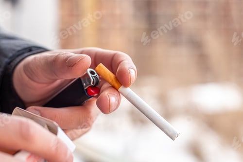 Preview: Male hands holding a cigarette and a lighter. Smoking concept.