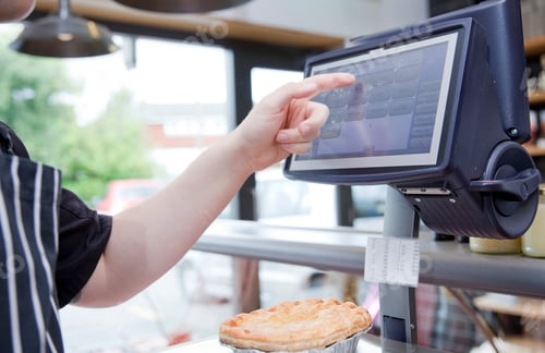 Preview: Cropped shot of butcher weighing pie in butchers shop