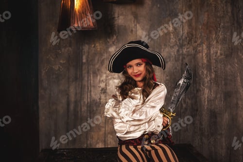 Portrait of pirate with saber sitting on chest in underground room or hold of pirates ship