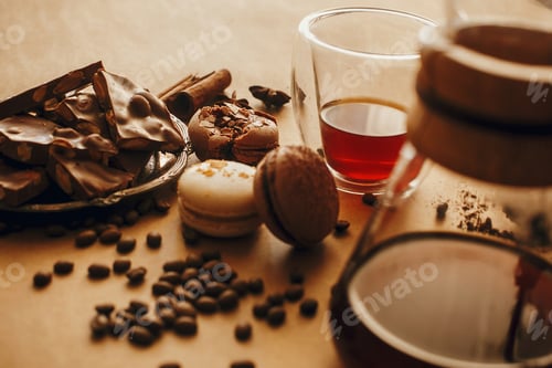 Preview: Coffee roasted beans, glass cup with fresh coffee, and macarons,chocolate, cinnamon
