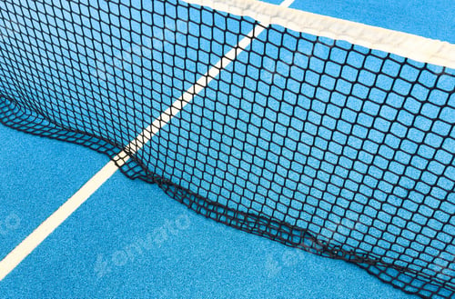 Preview: paddle tennis ball next to the net of a paddle tennis court.