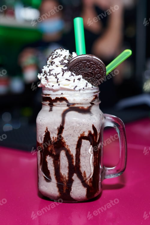 Preview: Vertical shot of a tasty cookie milkshake on a pink table
