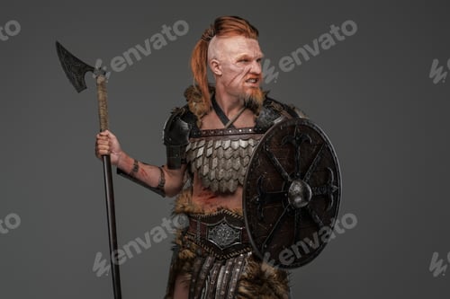 Preview: Barbaric viking warrior wielding axe and shield isolated on gray