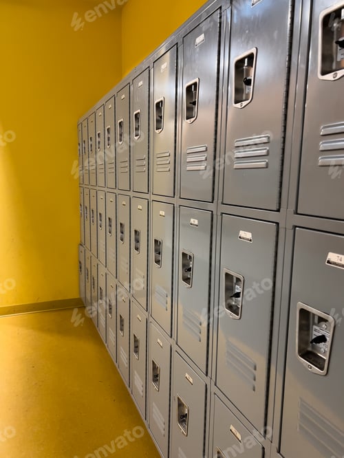 Preview: Rows of Gray School Lockers Lined up Against a Yellow Wall