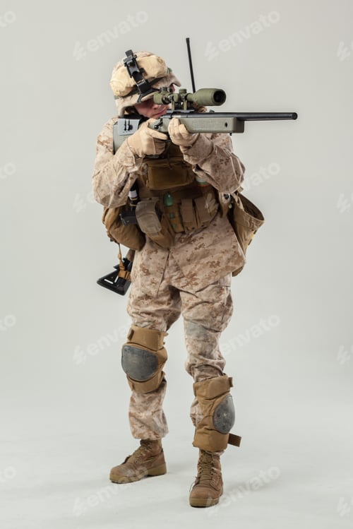 Preview: Military soldier stands ready with rifle in defensive stance indoors during daylight