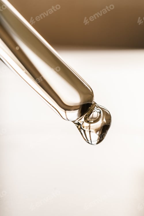 Preview: Pipettes with oil or serum on a golden background.