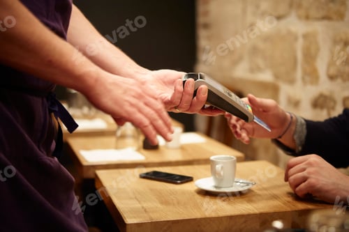Preview: Man paying his bill in restaurant, using credit card