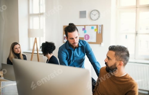 Preview: Group of young businesspeople with laptop working in a modern office.