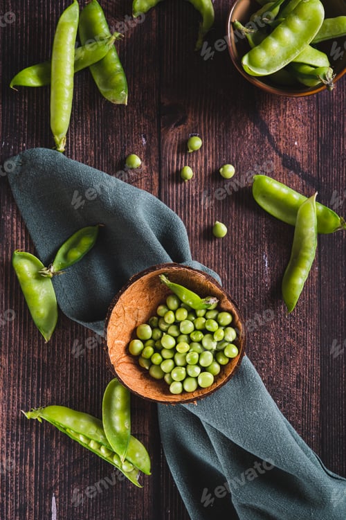 Preview: Bowl with green sugar peas on wooden table top and vertical view