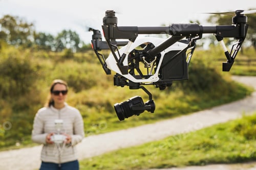 Preview: Woman flying drone using remote control
