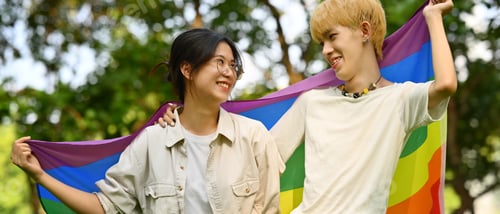 Preview: Image of young people with LGBTQ pride flag standing outdoo