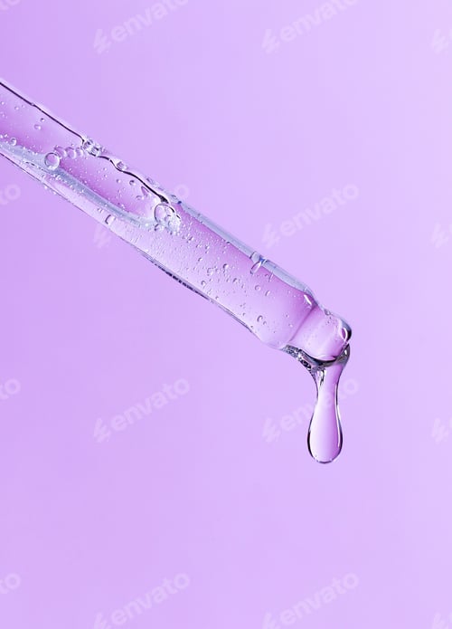 Preview: serum pipette close-up with falling drop on pink background