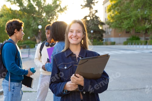 Preview: Happy young student holding folder on campus