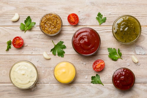 Preview: Many different sauces and herbs on table, flat lay top view. sauces with spices healthy concept