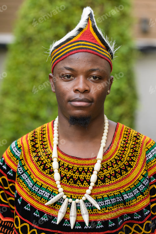 Preview: Face of young handsome African man wearing traditional clothing outdoors