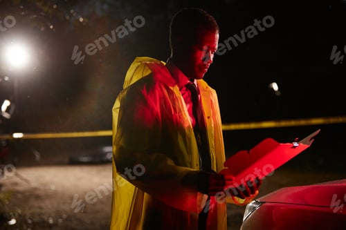 Preview: Black Police Office Reading Documents at Crime Scene