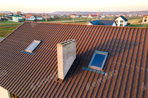 Preview: Closeup of house brick roof with yellow shingles cover and attic glass windows