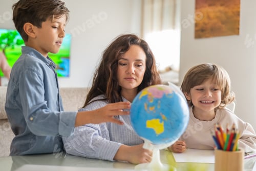 Preview: Two brothers learn geography with mother using globe, pointing countries and continents at home.