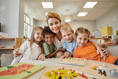 Preview: smiling teacher hugging multiethnic kids near didactic materials on table in montessori school