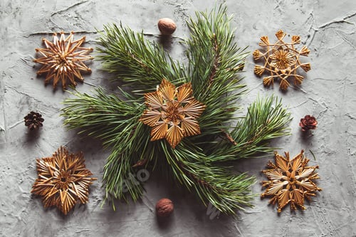 Preview: Homemade straw decor on Christmas tree close up. on a gray concrete background
