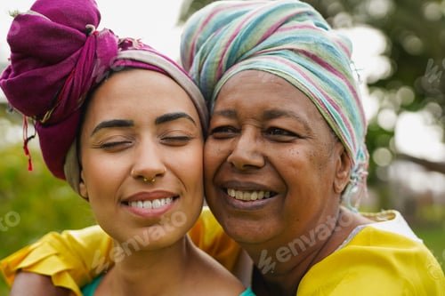 Preview: Happy african mother hugging daughter outdoor while wearing traditional clothes