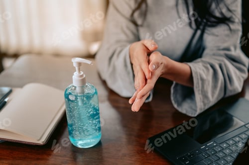 Vista previa: Young woman washing hands with alcohol gel in quarantine for coronavirus.Work from home