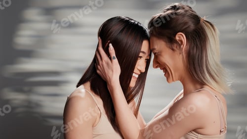 Preview: Beautiful natural women sharing hug in studio