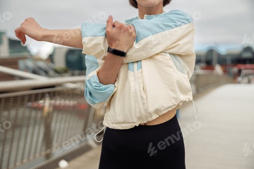Preview: Close up of sportive woman doing stretching exercise on footbridge in the city