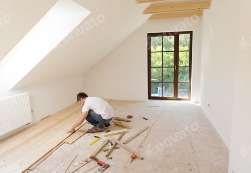 Man Installing Wooden Flooring in New Home