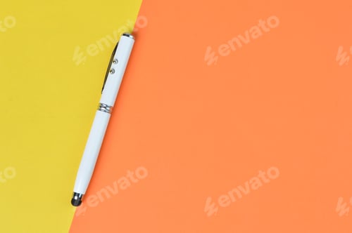 Preview: Top view of pen over yellow and orange paper with copy space. Business concept
