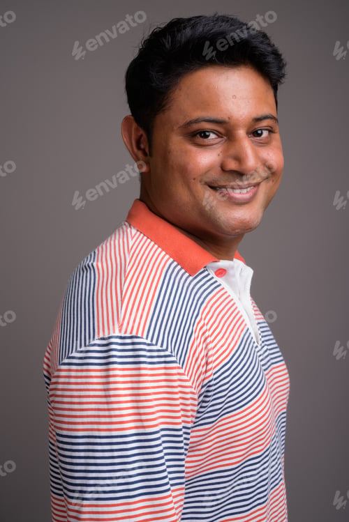 Preview: Portrait of young Indian man against gray background