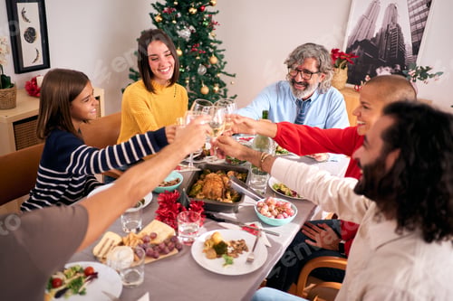 Preview: Happy Caucasian family celebrating winter vacations together drinking white wine at festive table.