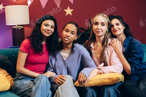 Preview: Diverse young women celebrating friendship and togetherness on sofa
