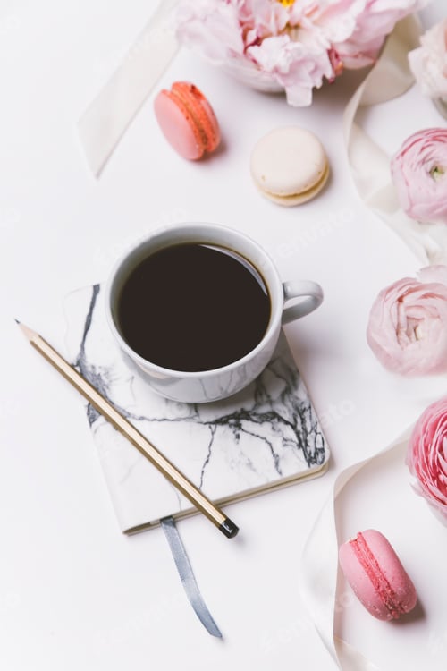 Preview: cup of coffee, pink flowers, perfume and macaroons on white background, top view