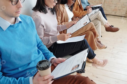 Preview: Row of young specialists with resume sitting in corridor