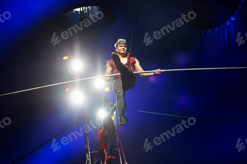 Preview: Acrobat Performance on Tightrope Under Dramatic Lighting