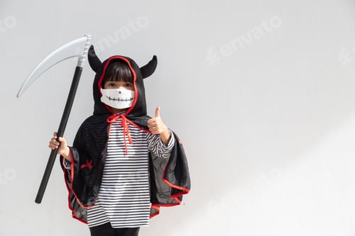 Preview: Asian little girl in a Halloween costume in a medical mask .