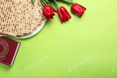 Preview: Matzos, Torah and flowers on green background, flat lay with space for text. Passover (Pesach) Seder